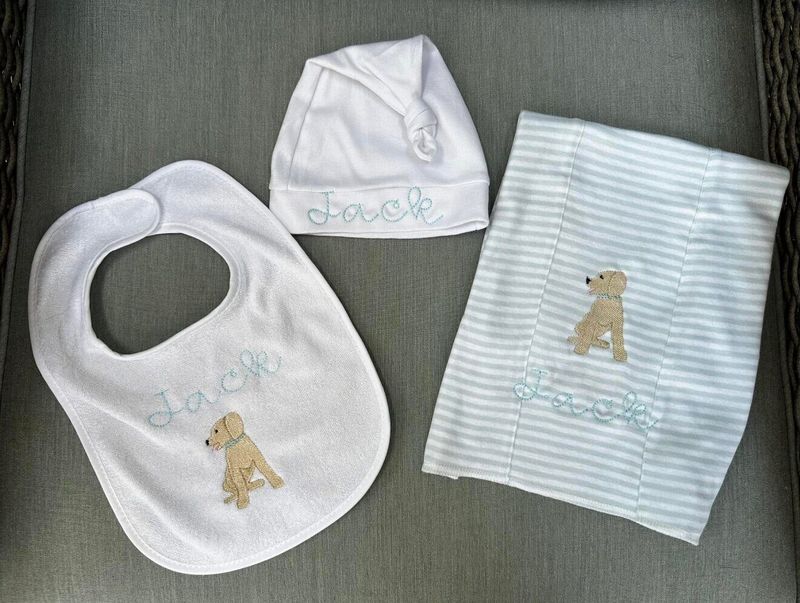 White bib, knot hat and striped burp cloth with Jack in light blue script and a yellow puppy
