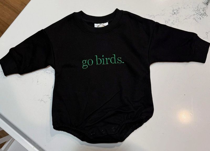 Black baby romper embroidered go birds. in green