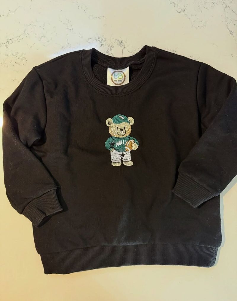 Kids black crewneck with an embroidered teddy bear in a green Philly jersey
