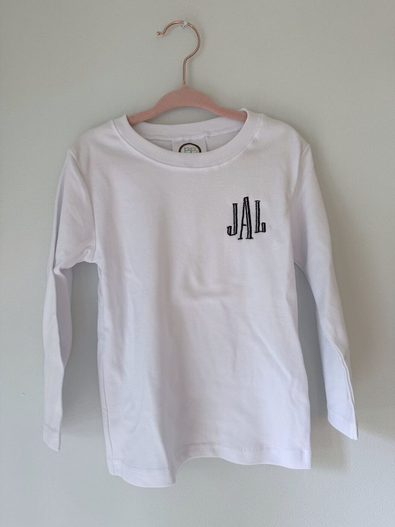 White tee with a JAL monogram in black